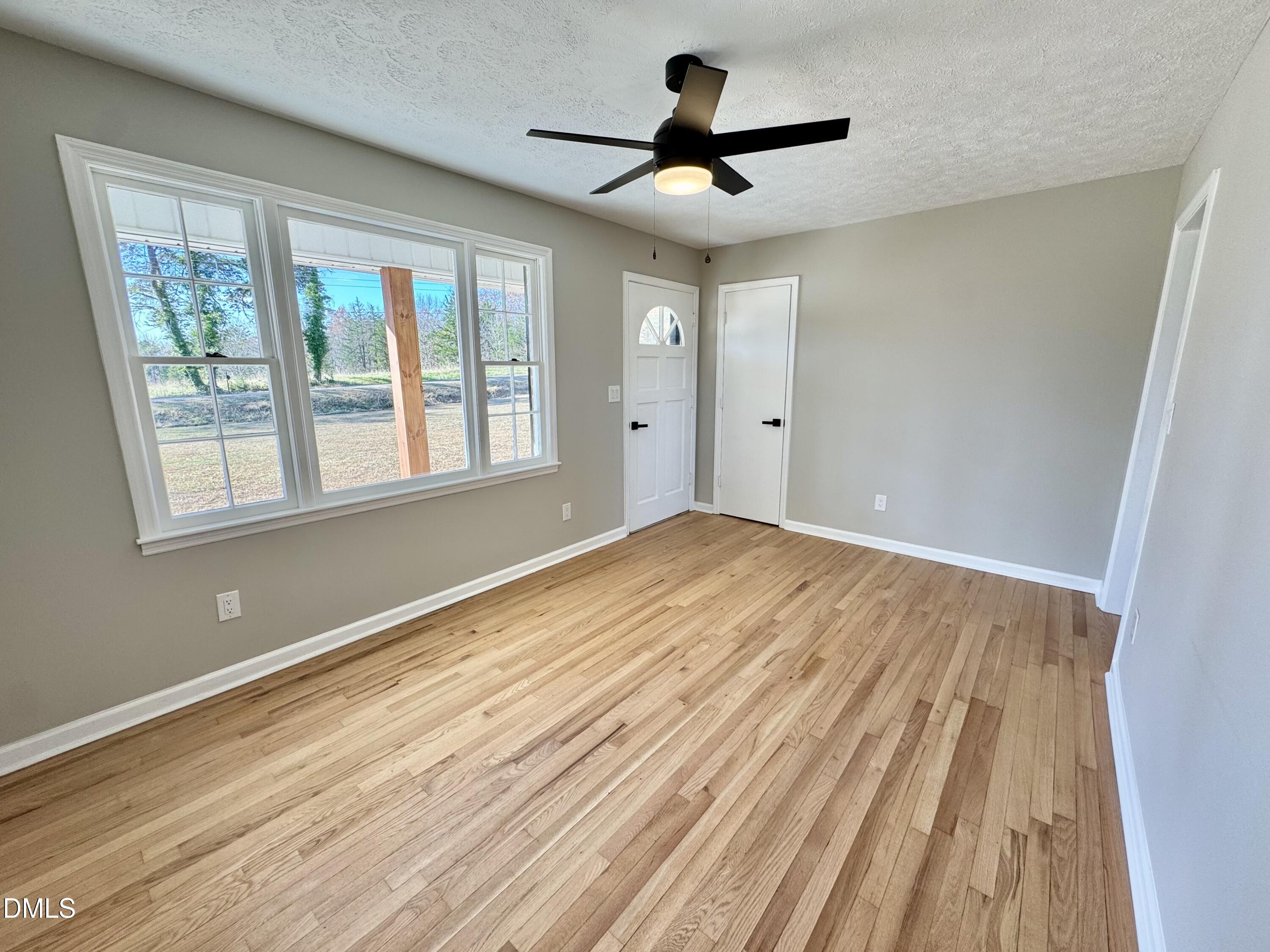 727 High Rock School Road Blanch, NC 27212 - Photo 3 of 29 a view of empty room with wooden floor and fan