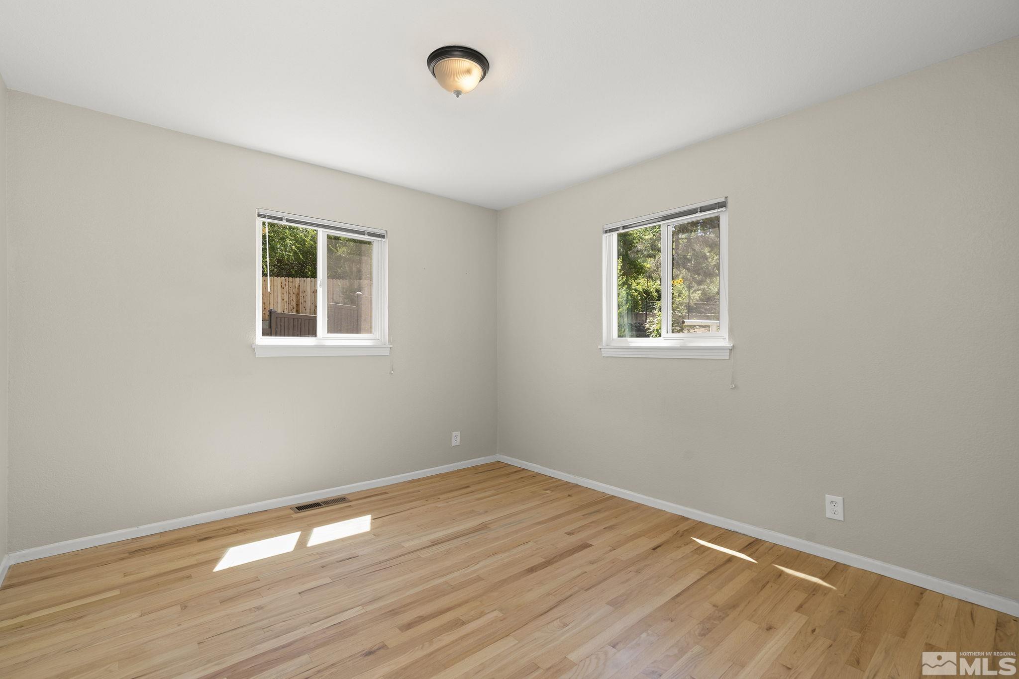 50 Kaye Way Reno, NV 89509 - Photo 11 of 16 an empty room with wooden floor and windows