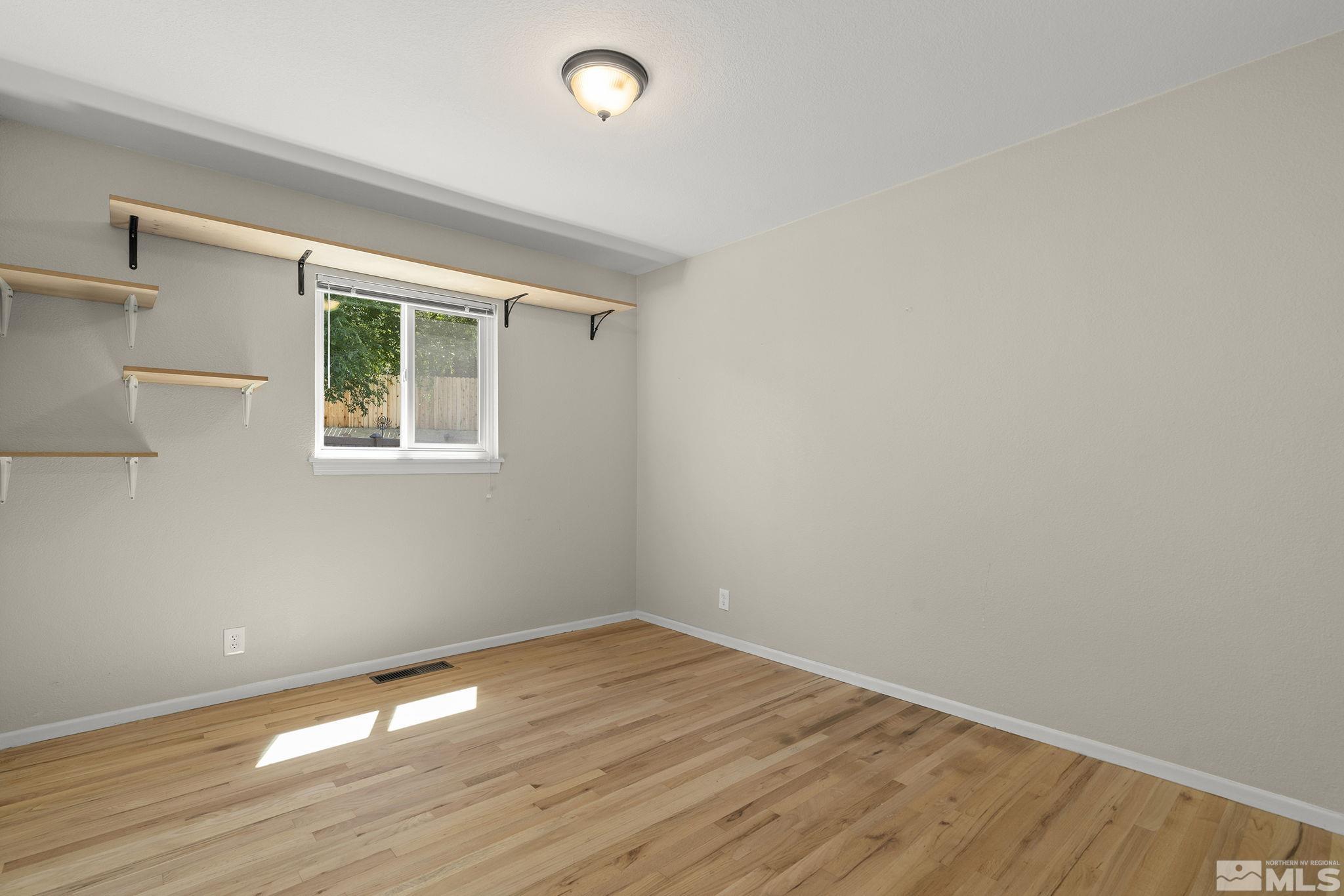 50 Kaye Way Reno, NV 89509 - Photo 12 of 16 an empty room with wooden floor and windows