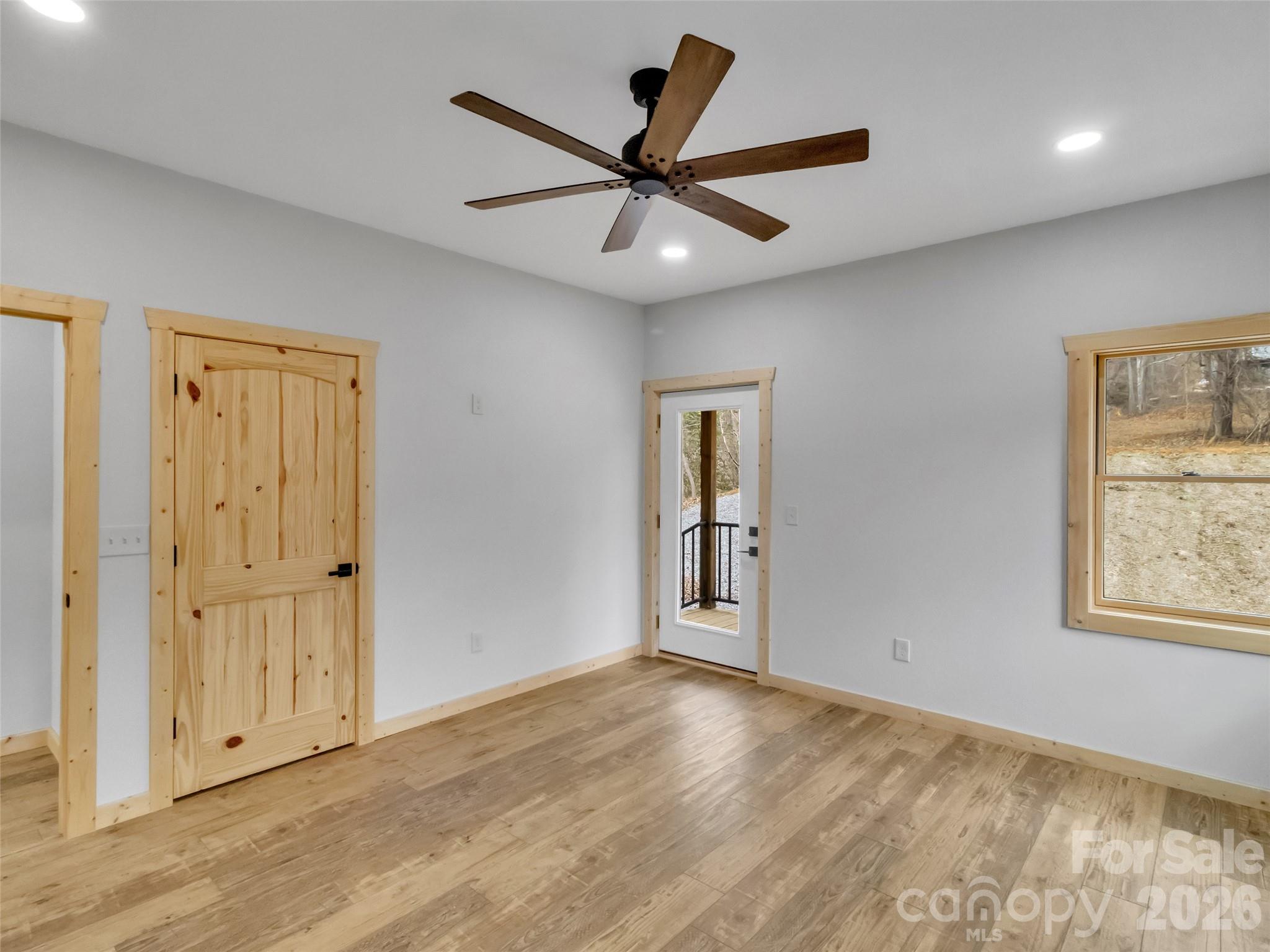 171 Cowtail Cove Clyde, NC 28721 - Photo 17 of 48 a view of an empty room with wooden floor and a ceiling fan