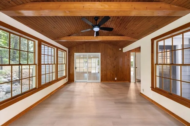an empty room with wooden floor and window