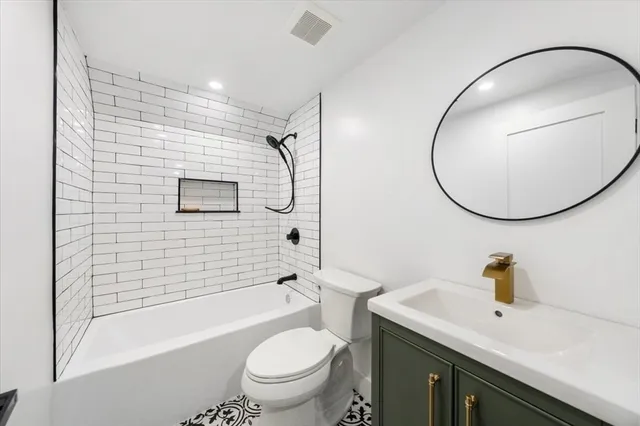 a bathroom with a bathtub shower sink vanity and toilet