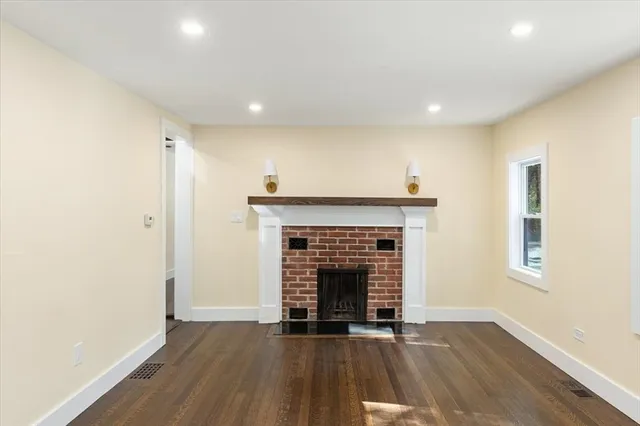an empty room with wooden floor and fireplace