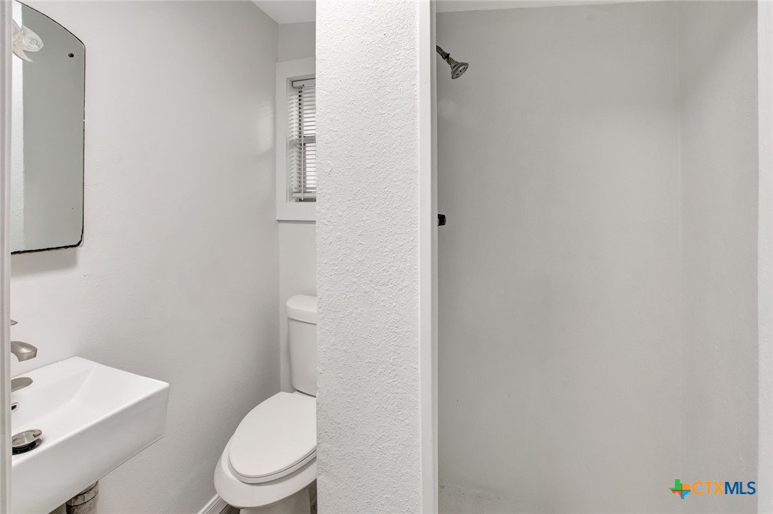 2907 Cedar Street Victoria, TX 77901 - Photo 25 of 45 a white toilet sitting next to a bathroom sink