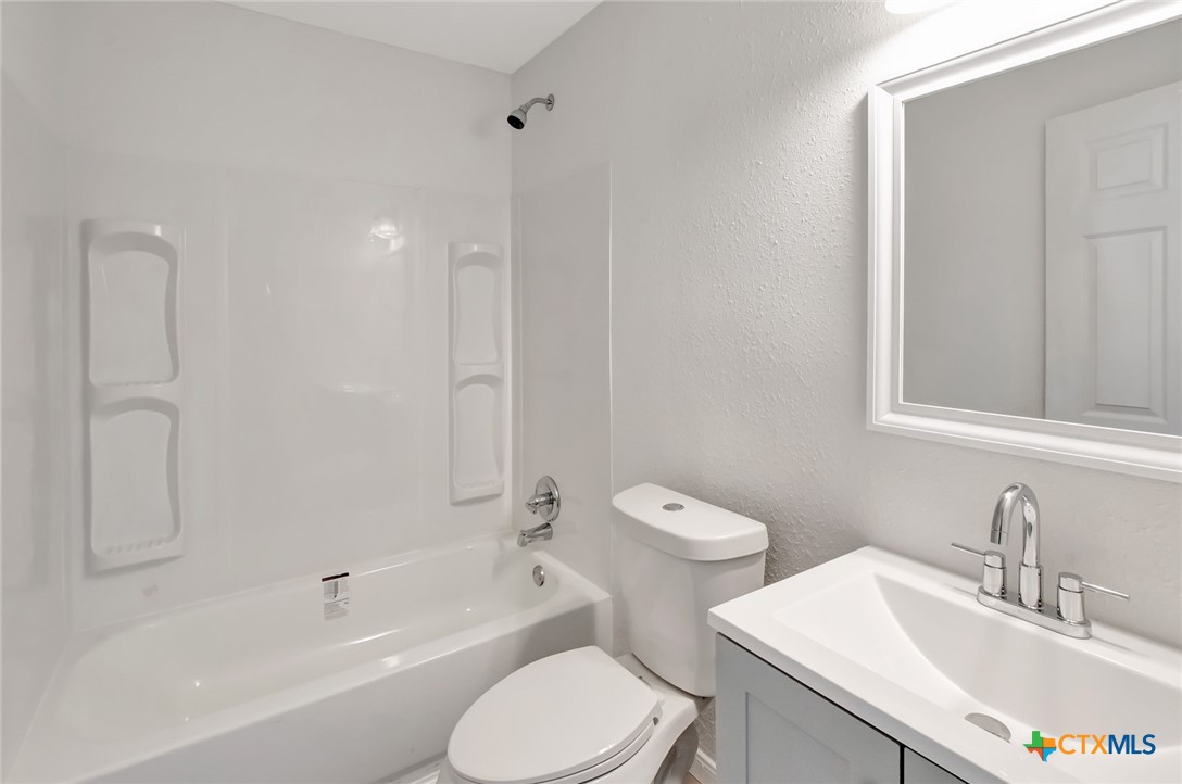 2907 Cedar Street Victoria, TX 77901 - Photo 27 of 45 a bathroom with a bathtub shower sink mirror vanity and toilet