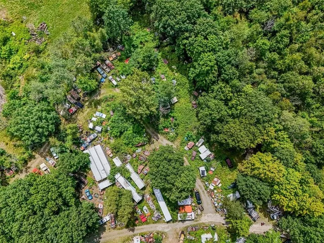 an aerial view of residential houses with outdoor space and trees