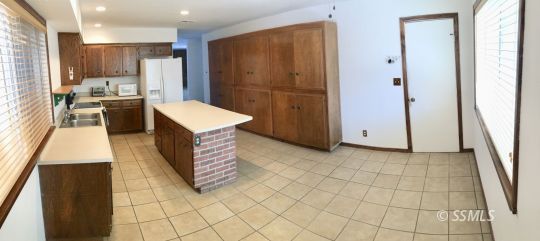 509 South Helena Street Ridgecrest, CA 93555 - Photo 9 of 40 a kitchen with stainless steel appliances kitchen island granite countertop a refrigerator and a stove