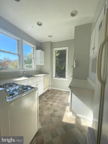 a kitchen with stainless steel appliances granite countertop a refrigerator a stove and a sink