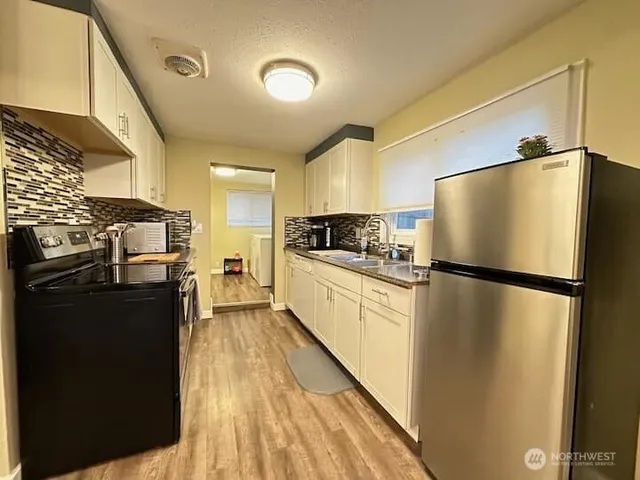 a kitchen with a refrigerator a sink and cabinets