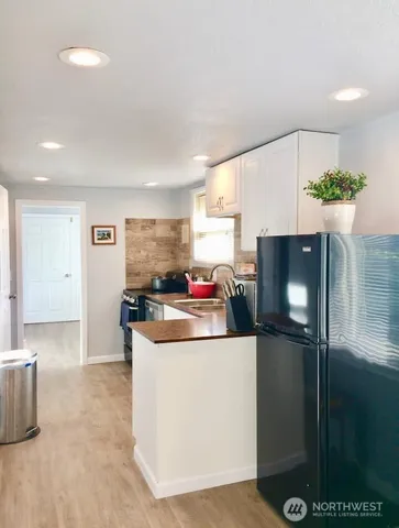 a kitchen with stainless steel appliances a stove a refrigerator a sink a counter top space and cabinets