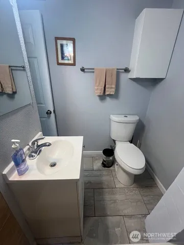 a bathroom with a toilet sink and mirror