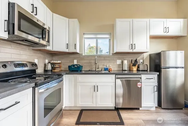 a kitchen with cabinets stainless steel appliances and a counter space