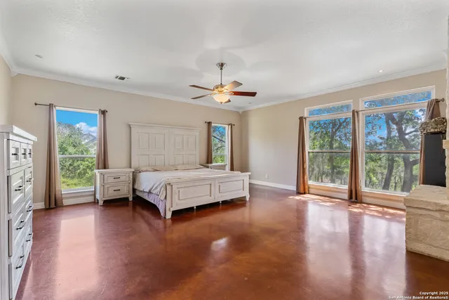 a spacious bedroom with a large bed and a large window with wooden floor