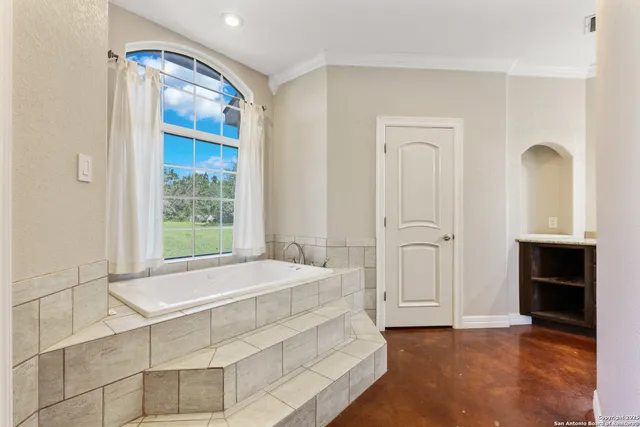 a spacious bedroom with a bed and a window