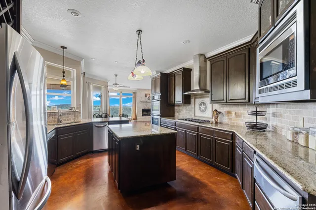 a kitchen with stainless steel appliances granite countertop refrigerator a sink dishwasher a stove top oven a refrigerator with wooden floor