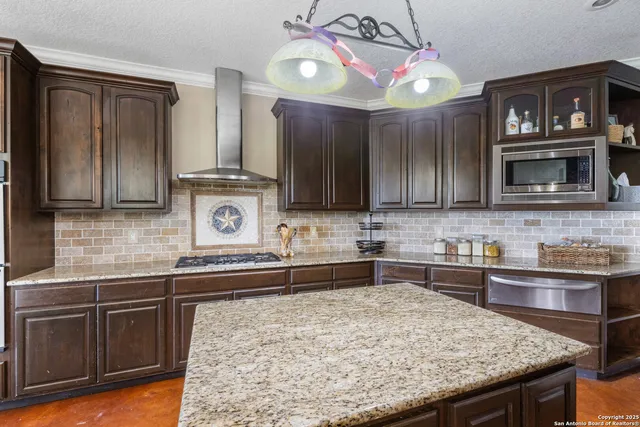a kitchen with stainless steel appliances granite countertop wooden cabinets and a sink