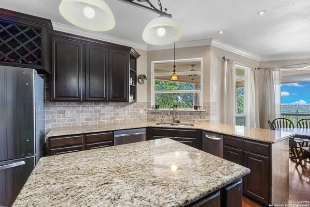 a kitchen with stainless steel appliances granite countertop a sink stove and refrigerator