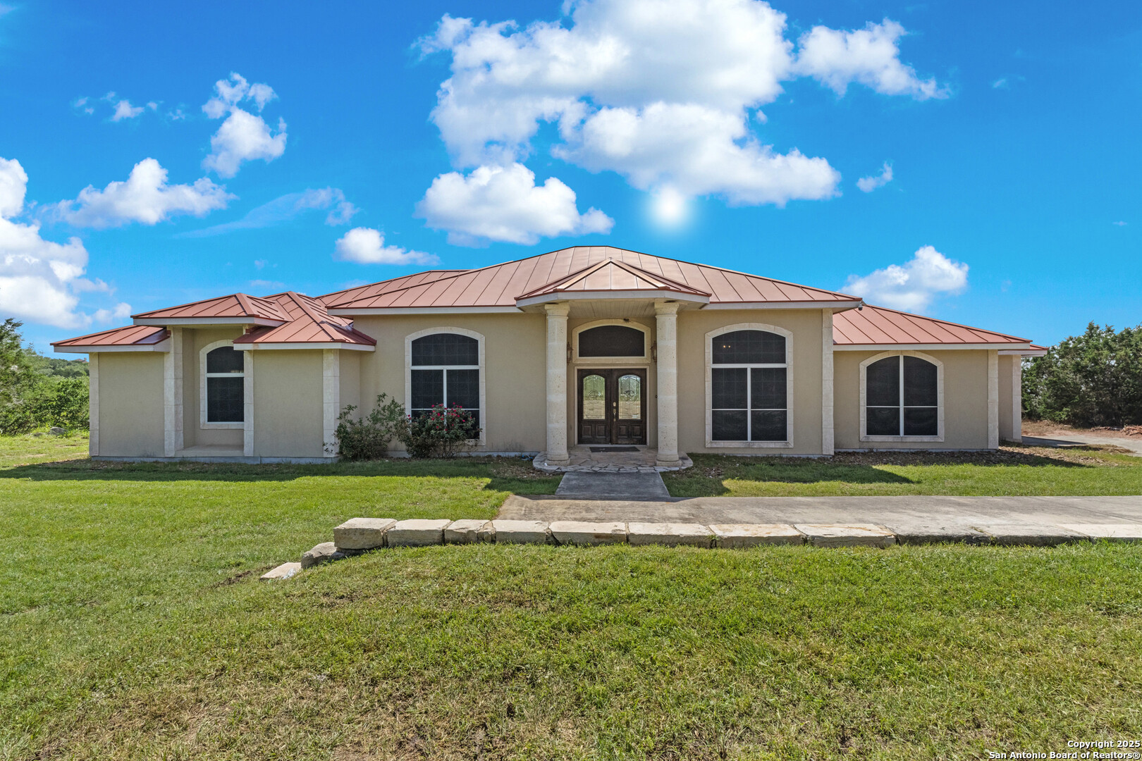 165 County Road 2740 Mico, TX 78056 - Photo 2 of 30 a front view of a house with a garden
