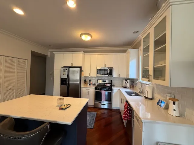 a kitchen with a refrigerator a stove a sink dishwasher with a dining table and chairs