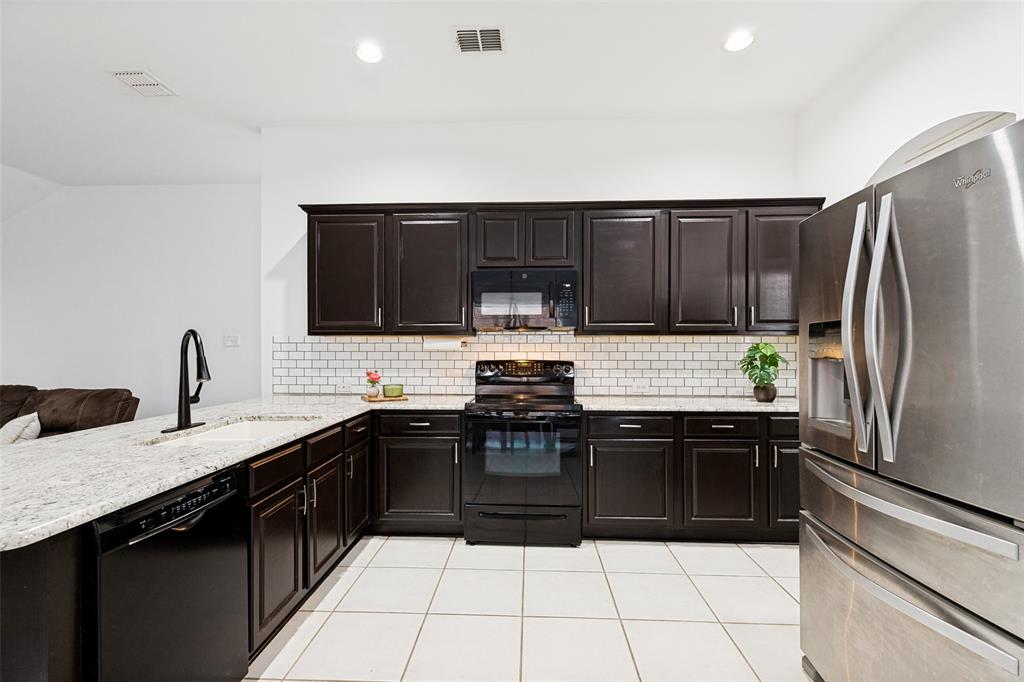 4305 Ridgewood Road Melissa, TX 75454 - Photo 8 of 26 Kitchen featuring dark wood-finish cabinetry, white subway tile backsplash, light-toned granite countertops, and white tile flooring