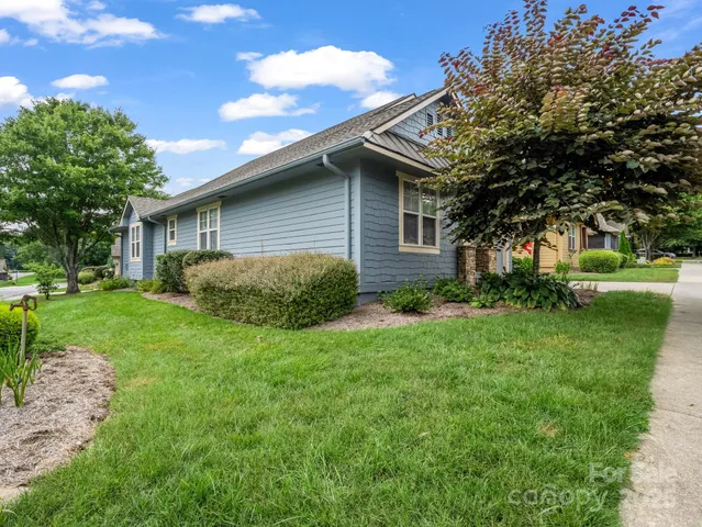 a view of backyard of house with green space