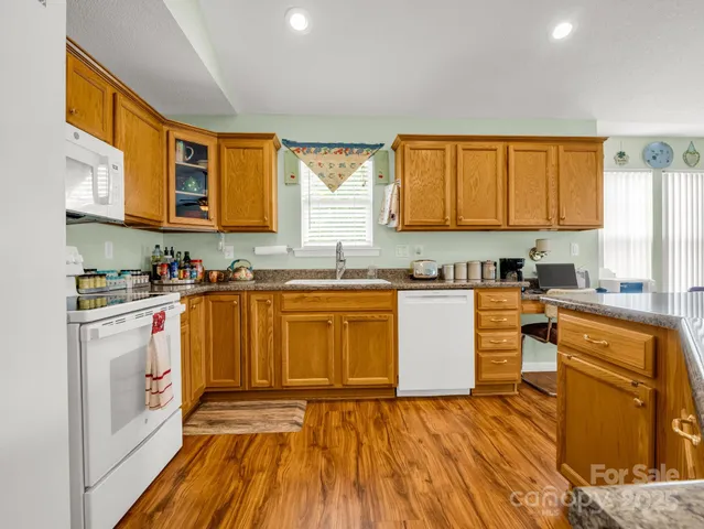 a kitchen with stainless steel appliances granite countertop a stove a sink and a microwave