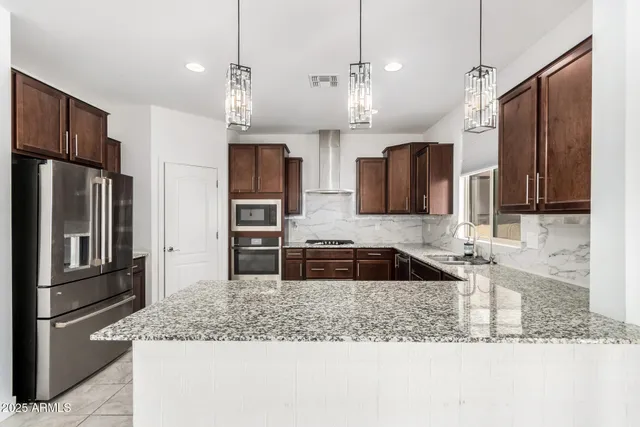 a kitchen with stainless steel appliances granite countertop a refrigerator and a sink
