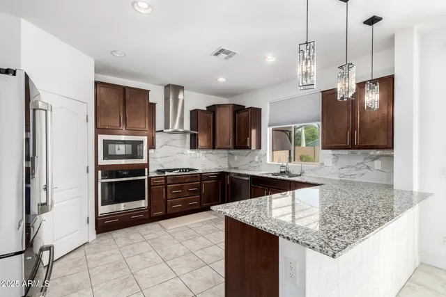 a kitchen with stainless steel appliances granite countertop a sink refrigerator and stove