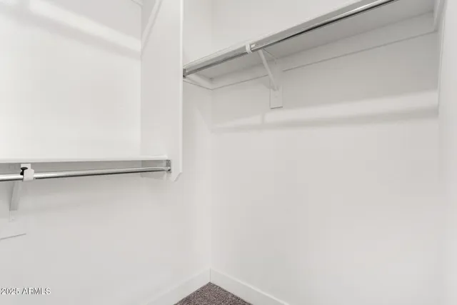 an empty room with a ceiling fan and carpet