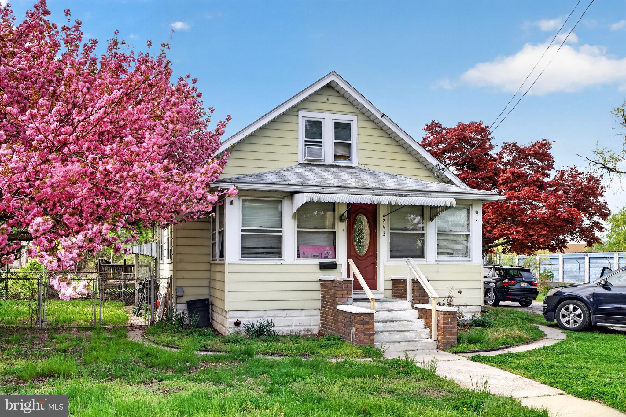 242 Broad Street Carneys Point, NJ 08069 - Photo 2 of 6 a front view of a house with a garden and trees