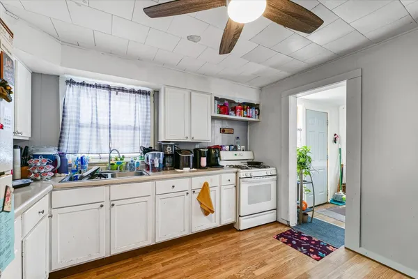 a kitchen with a sink cabinets and wooden floor