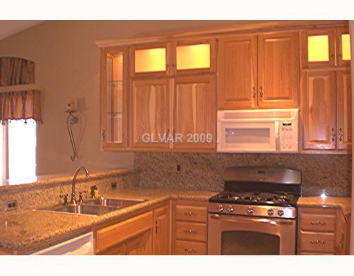 929 Longshanks Road Henderson, NV 89015 - Photo 4 of 7 Kitchen. NOTE ALL THE GRANITE AND BACKSPLASH W/ CUSTOM HICKORY CABINETS AND DESPLAY CABINETS