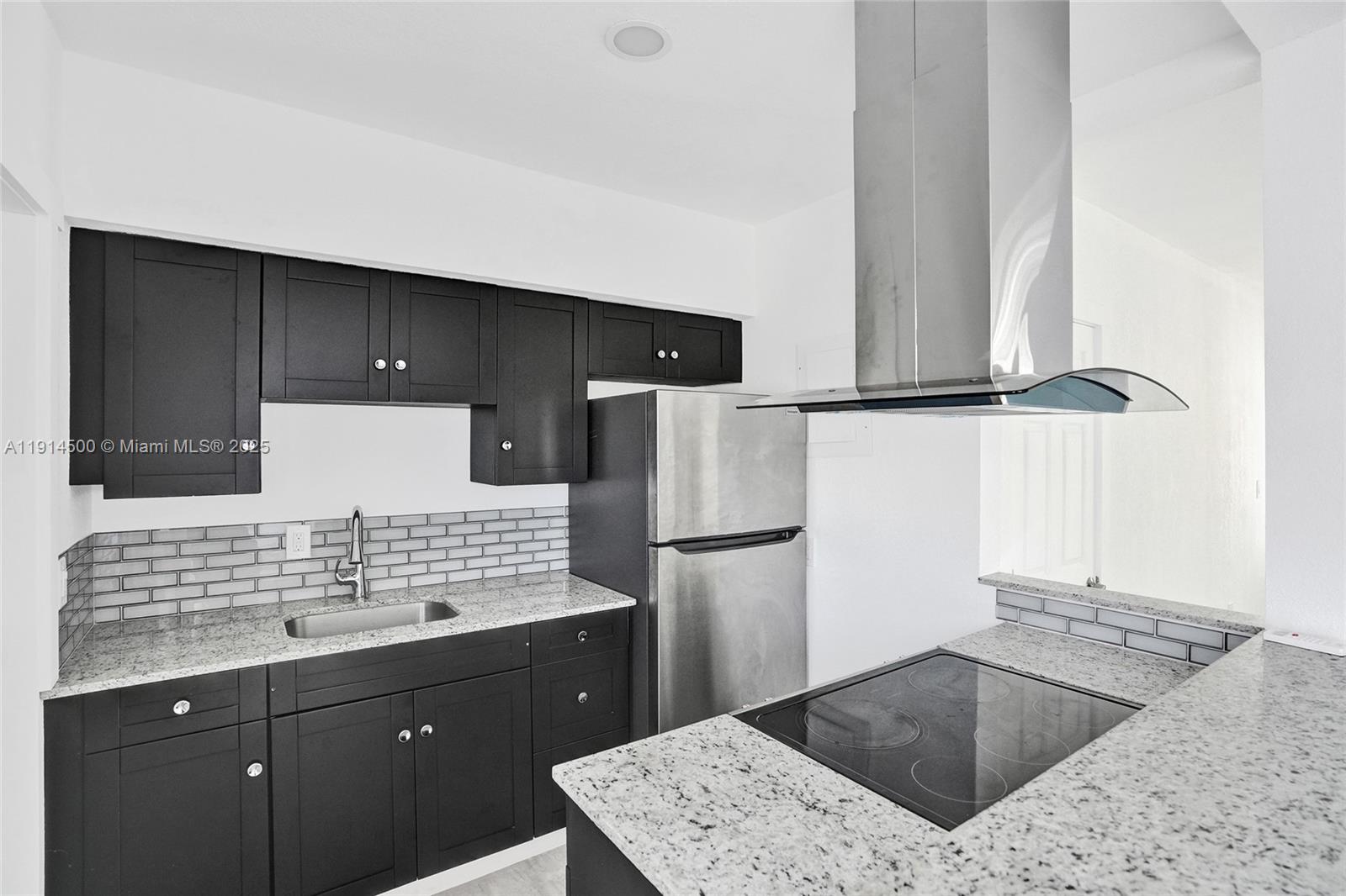 7115 Rue Granville, Unit C Miami Beach, FL 33141 - Photo 15 of 25 a view of kitchen with a sink a refrigerator and a stove