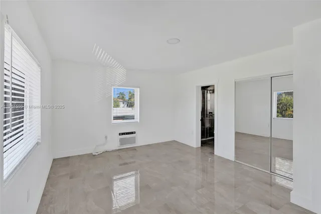 an empty room with windows and cabinet