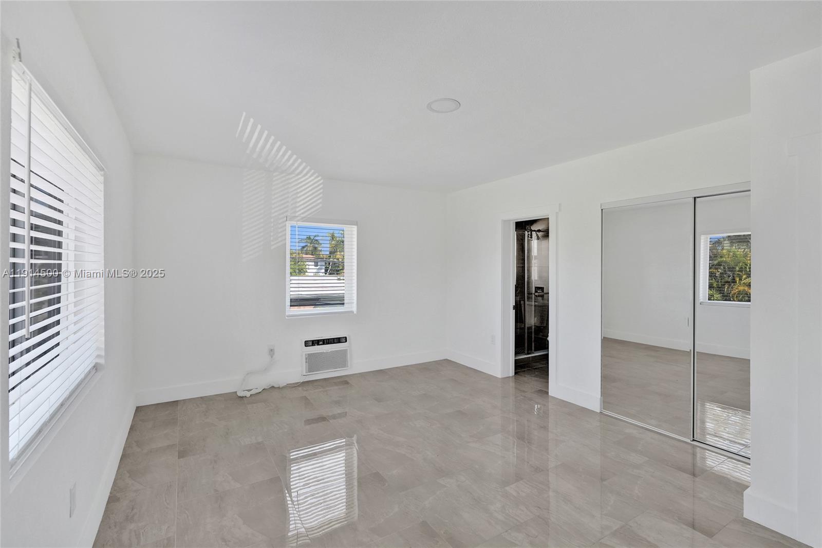 7115 Rue Granville, Unit C Miami Beach, FL 33141 - Photo 19 of 25 an empty room with windows and cabinet