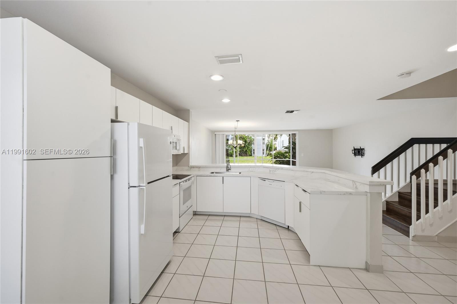 6215 Old Court Road, Unit 505 Boca Raton, FL 33433 - Photo 8 of 36 a kitchen with white cabinets and white appliances