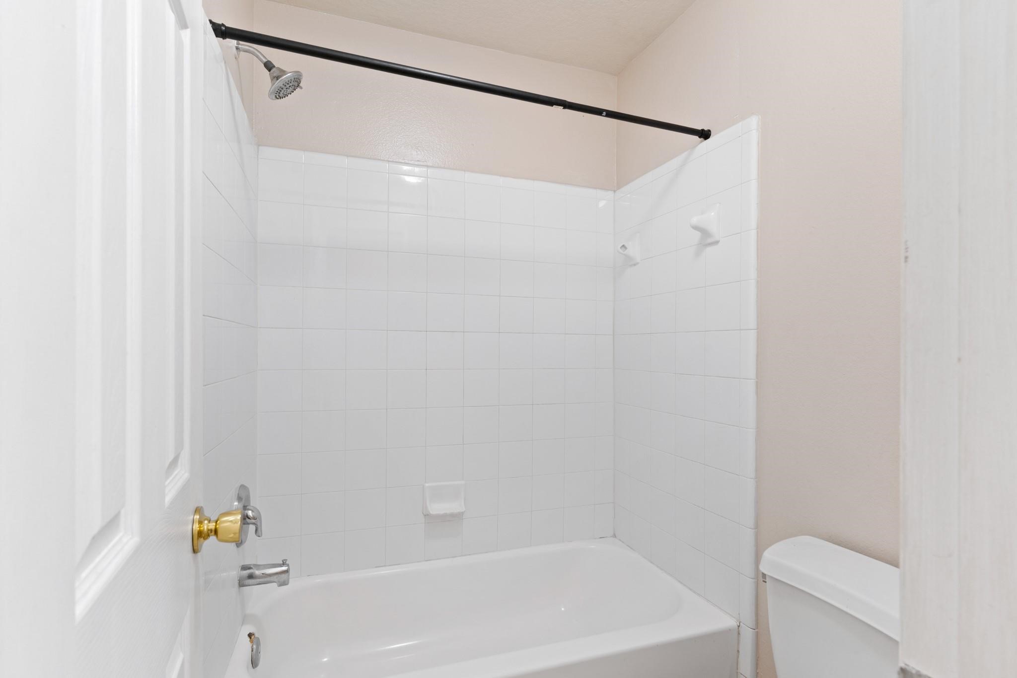 5038 Forest Hurst Drive Spring, TX 77373 - Photo 12 of 22 a bathroom with a shower and a bath tub