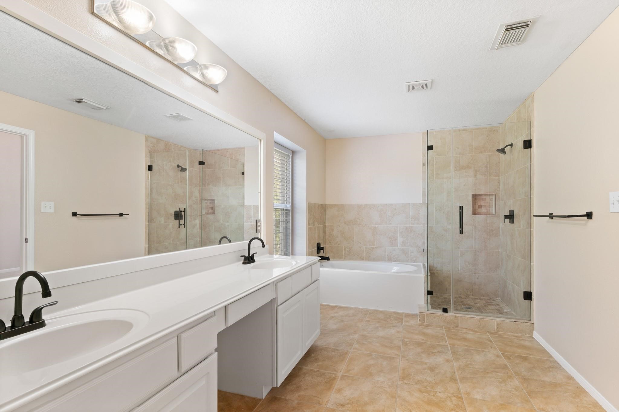 5038 Forest Hurst Drive Spring, TX 77373 - Photo 16 of 22 a bathroom with a double vanity sink a mirror and a bathtub