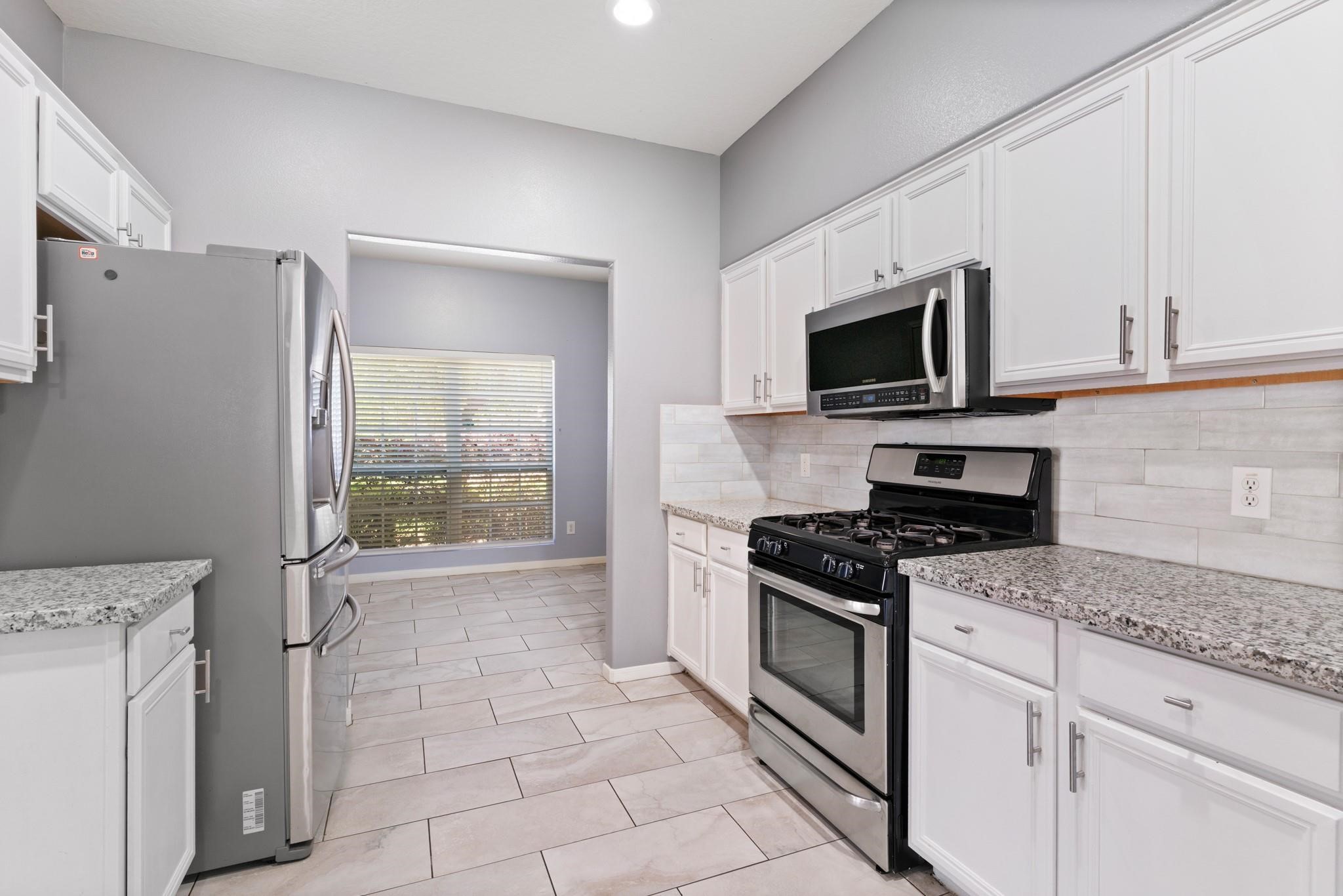 5038 Forest Hurst Drive Spring, TX 77373 - Photo 7 of 22 a kitchen with a stove a sink and a microwave