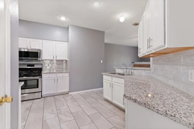 a kitchen with stainless steel appliances granite countertop a sink and a stove
