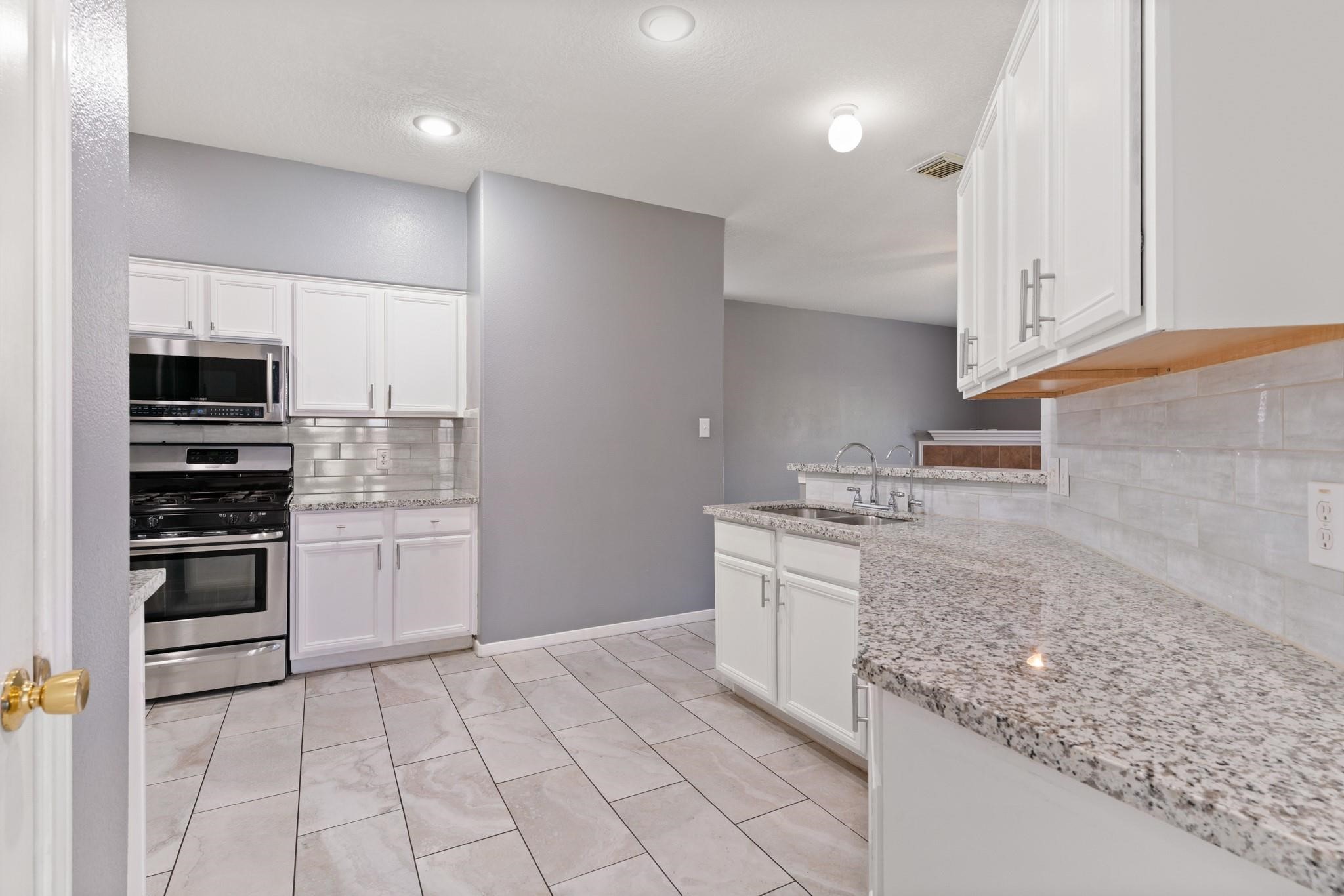 5038 Forest Hurst Drive Spring, TX 77373 - Photo 9 of 22 a kitchen with stainless steel appliances granite countertop a sink and a stove