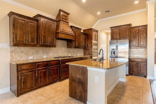 a kitchen with stainless steel appliances granite countertop a sink and dishwasher a stove top oven with wooden floor