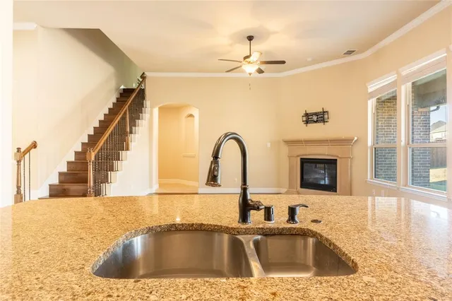 a kitchen with a sink a faucet a window and a fireplace