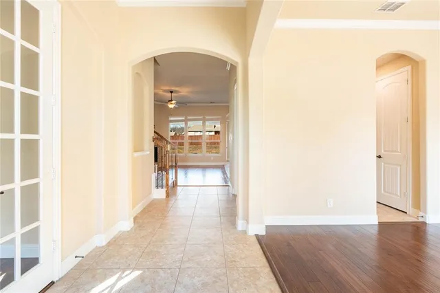 a view of a hallway with wooden floor and a bathroom