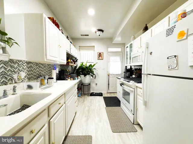 a kitchen with stainless steel appliances a stove a sink and a refrigerator
