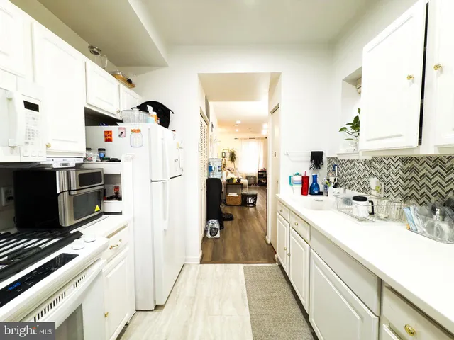 a kitchen with granite countertop a stove a refrigerator and a sink