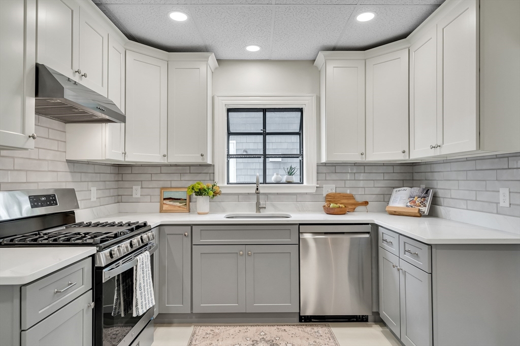 62 Florence Road Waltham, MA 02453 - Photo 13 of 42 a kitchen with stainless steel appliances granite countertop a sink stove and cabinets