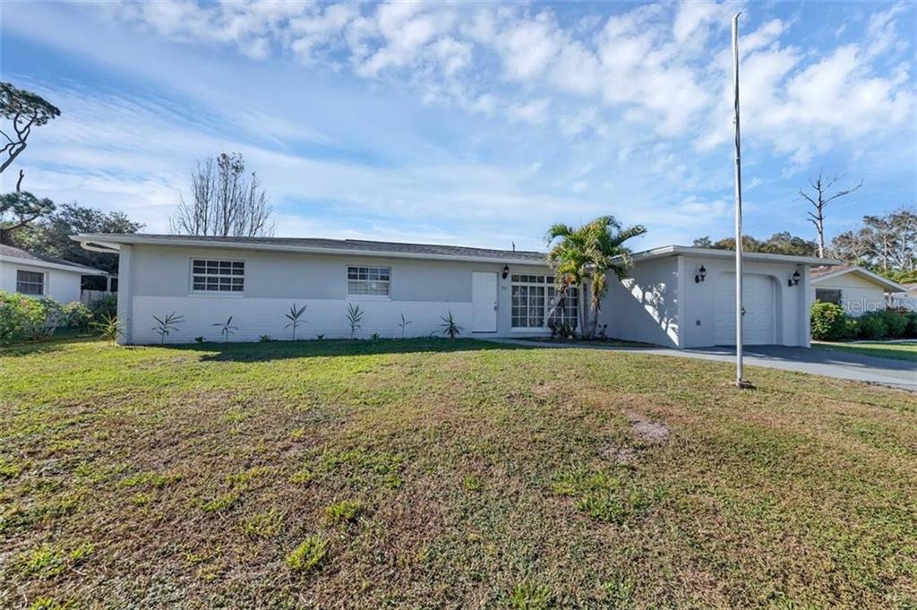 a view of a house with a backyard and a tree