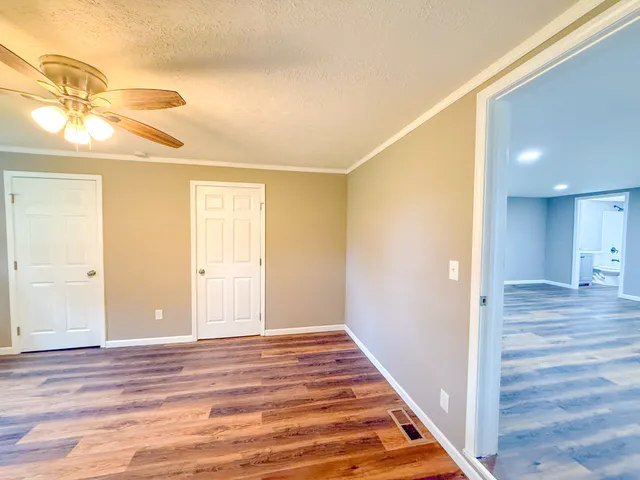 a view of a hallway with wooden floor and staircase