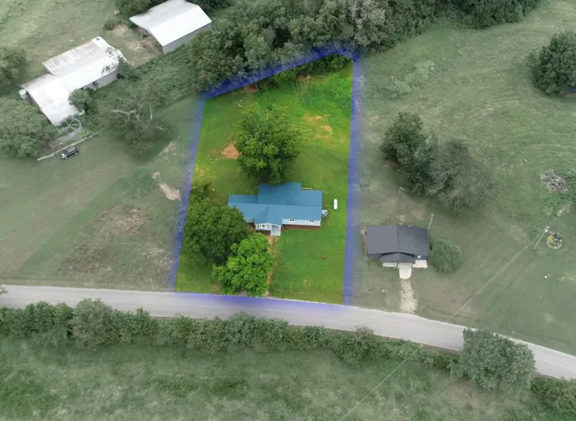 an aerial view of a house with a yard